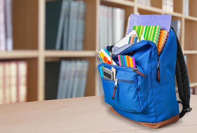 Sac à dos bleu avec différentes fournitures scolaires