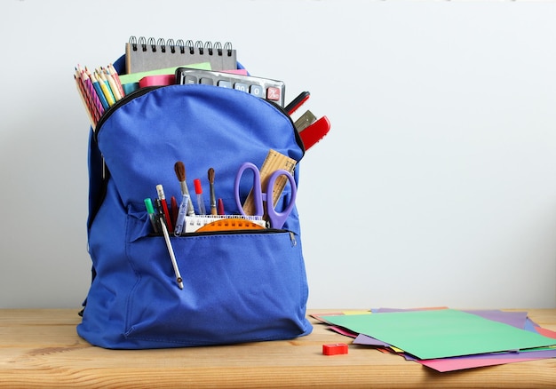 Sac à dos bleu avec des fournitures scolaires