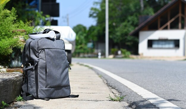 Sac à dos avec casque placé sur le bord de la route en attendant un voyage, Travel concept.