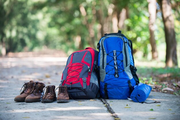 Photo sac à dos et chaussures les randonneurs se reposent sur la route pendant leur randonnée