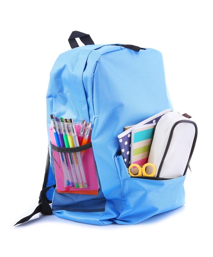 Photo sac à dos avec des fournitures scolaires isolé sur blanc