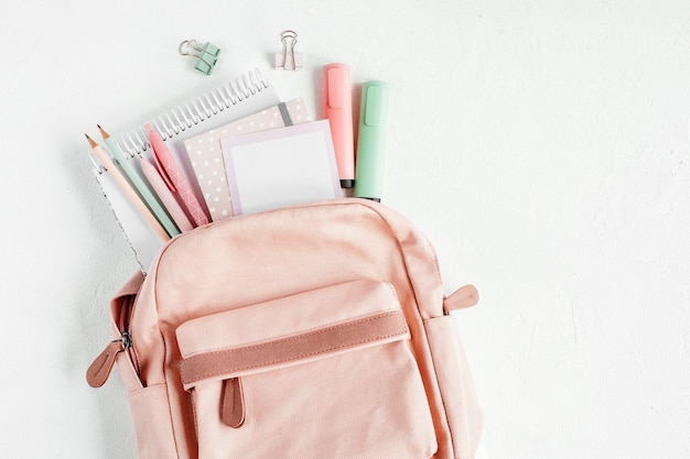 Sac à dos avec fournitures scolaires et livres d'étude. Retour au concept de l'école. Mise à plat, vue de dessus