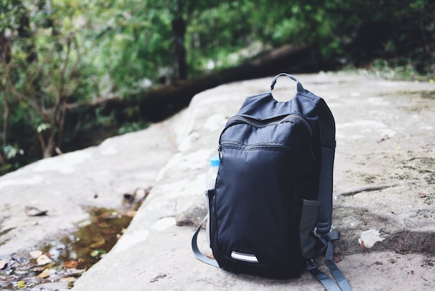 Sac à dos sur la nature avec une bouteille pour randonneur randonneur sur le rocher dans la forêt en montagne