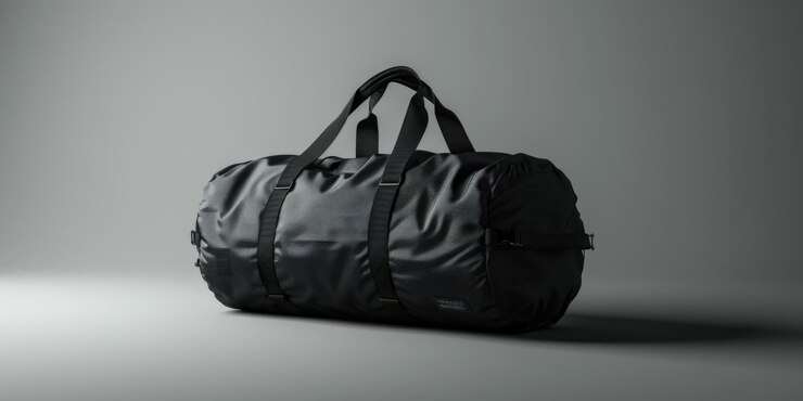 Un sac à dos noir solitaire est assis sur un sol gris en attendant sa prochaine aventure.