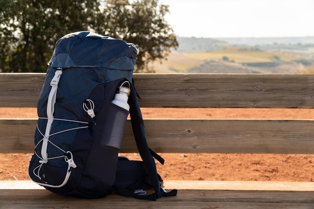 Sac à dos de randonnée sur un banc en bois dans la nature