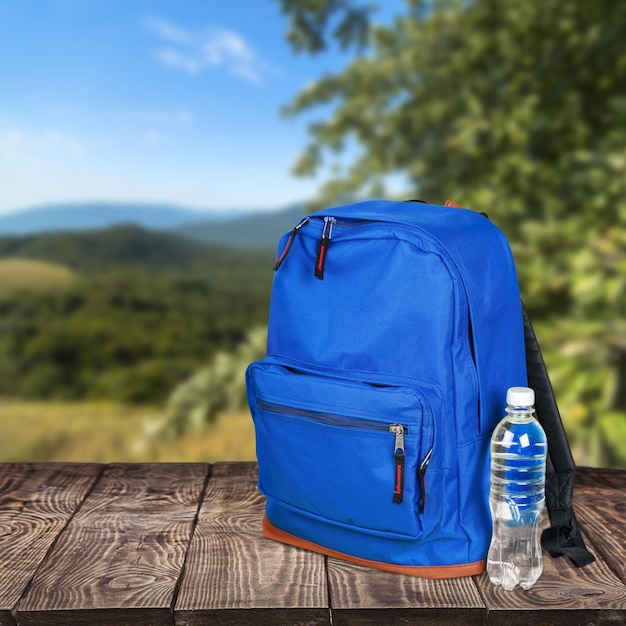 Sac à dos scolaire bleu et eau sur table en bois