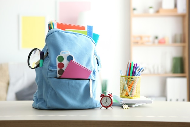 Sac à dos scolaire et papeterie dans une pièce lumineuse