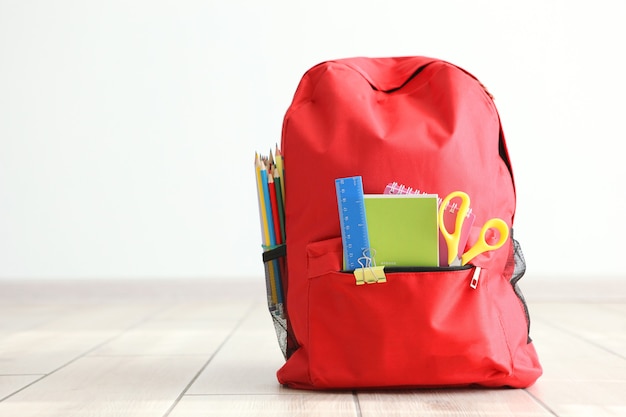 Sac à dos scolaire et papeterie dans une pièce lumineuse