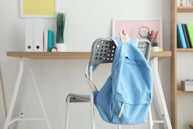 Sac à dos scolaire et papeterie dans une pièce lumineuse