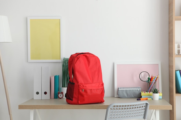 Sac à dos scolaire et papeterie dans une pièce lumineuse