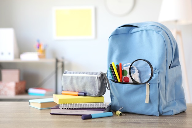 Sac à dos scolaire et papeterie dans une pièce lumineuse