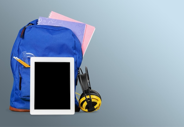 Sac à dos scolaire avec tablette et casque sur table