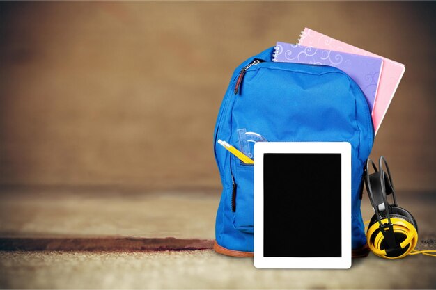 Sac à dos scolaire avec tablette et écouteurs sur table