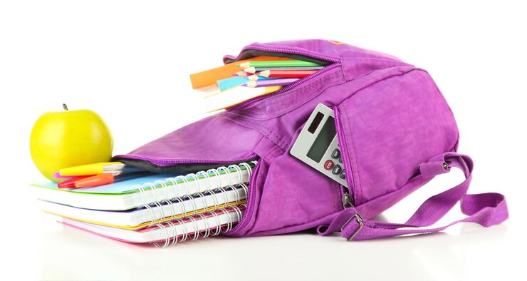 Photo sac à dos violet avec des fournitures scolaires isolées sur blanc