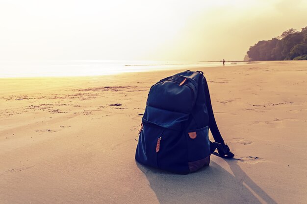 Sac à dos de voyage sur la plage de la mer d'été. le concept de tourisme de voyage, de loisirs et de randonnée