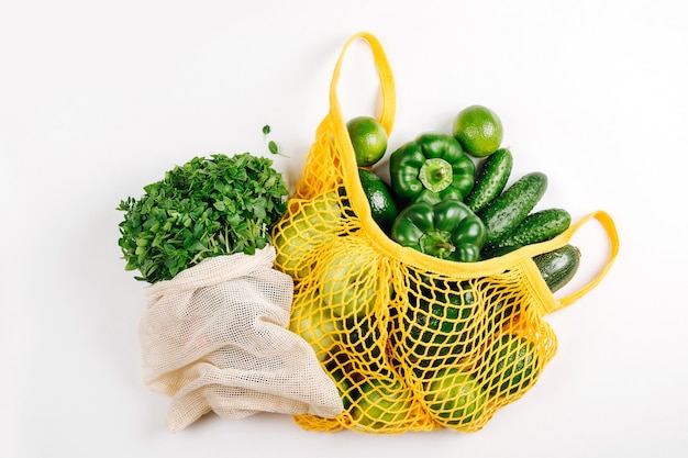 Sac éco et sac de marché en filet jaune avec légumes bio