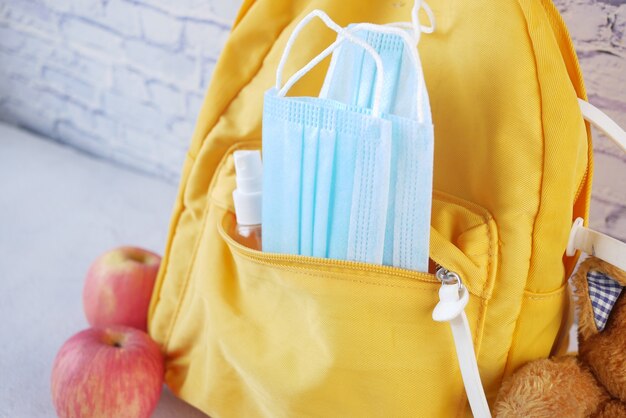 Sac d'école étudiant avec désinfectant un masque facial