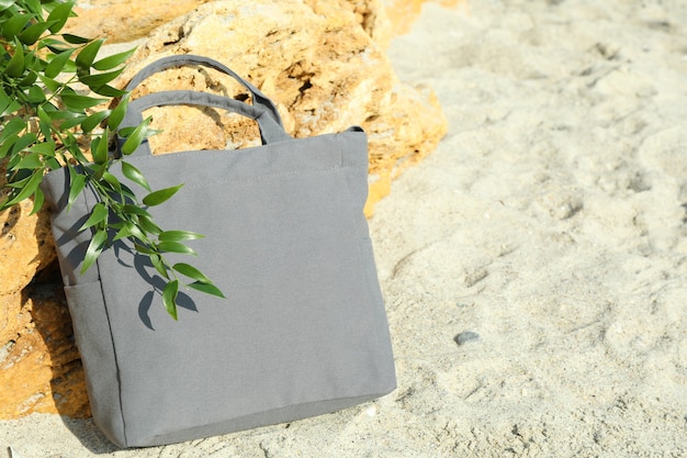 Sac écologique élégant et brindille en plein air sur la plage, espace pour le texte