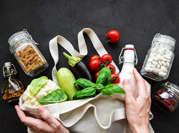 Sac écologique avec fruits et légumes, bocaux en verre avec haricots et pâtes