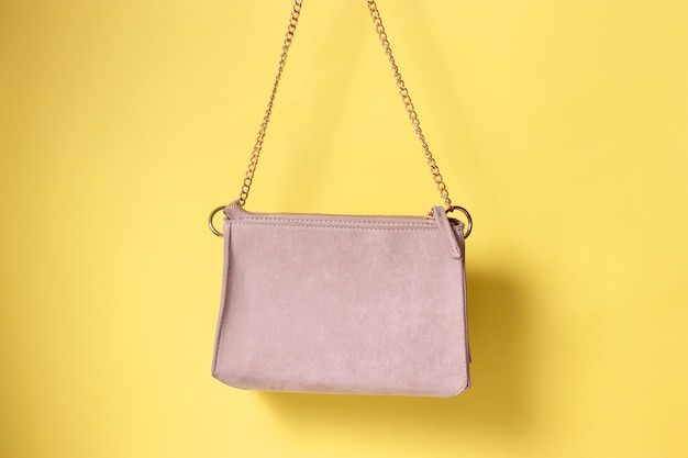 Sac femme à la main sur fond coloré