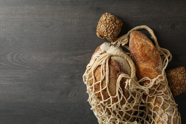 Sac de ficelle avec du pain sur fond noir