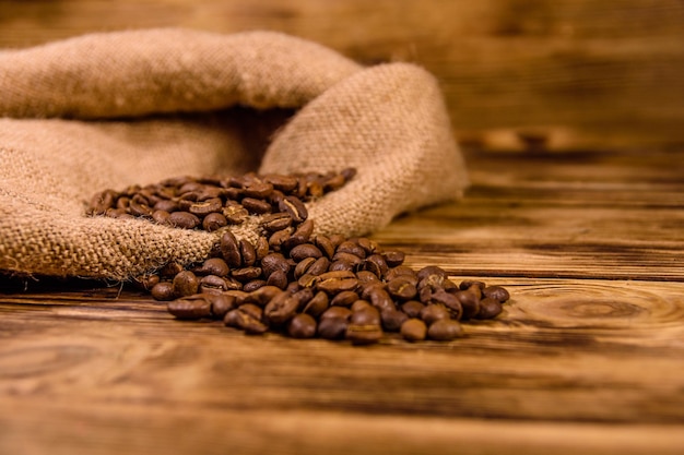 Un sac et des grains de café éparpillés sur une table en bois