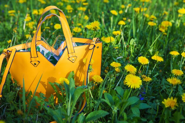Le sac jaune se tient sur l'herbe verte, plan rapproché