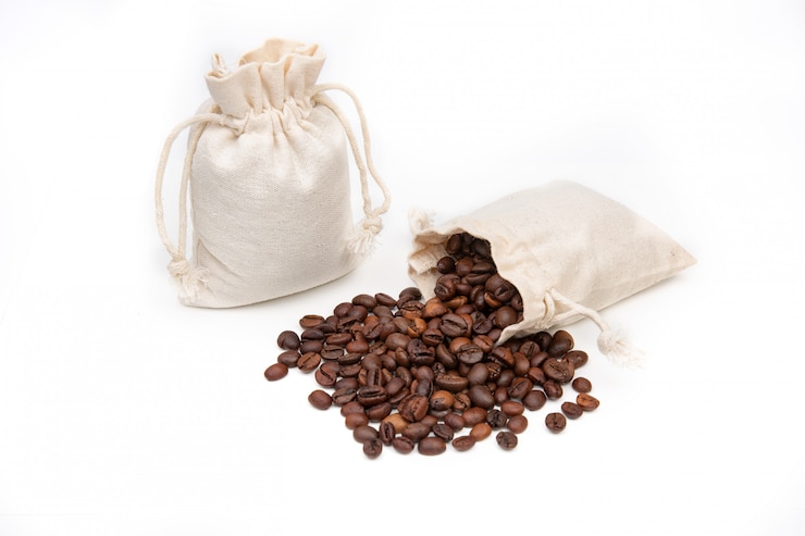 Photo sac de jute ou de lin avec des grains de café sur un espace blanc