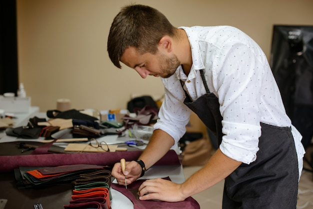 Sac à main en cuir artisan au travail dans un atelier