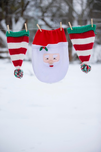 Le sac de Noël du Père Noël et les chapeaux rayés sont séchés sur une corde Se préparant à célébrer Noël