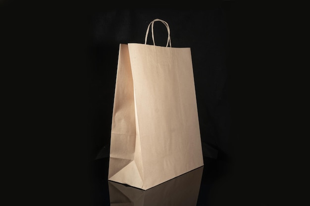 Sac en papier artisanal recyclable pour les achats de cadeaux et de plats à emporter maquette sur fond noir Respectueux de l'environnement que les sacs en plastique à usage unique