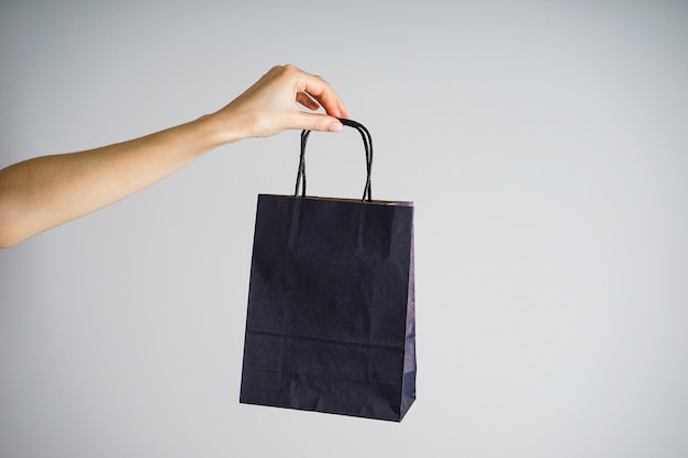 Sac en papier bleu dans une main féminine