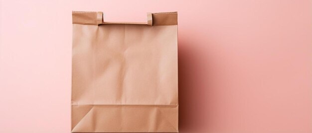 Photo un sac en papier brun est ouvert sur un mur rose
