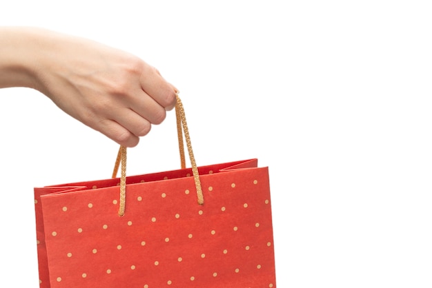 Sac en papier dans les mains de la femme isolé sur mur blanc.