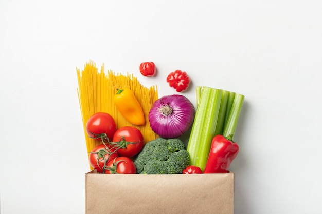 Sac en papier de différents aliments sains sur une table.