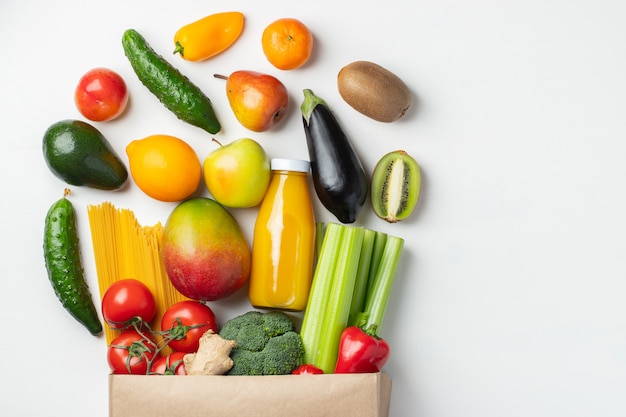 Sac en papier de différents aliments de santé sur une table.