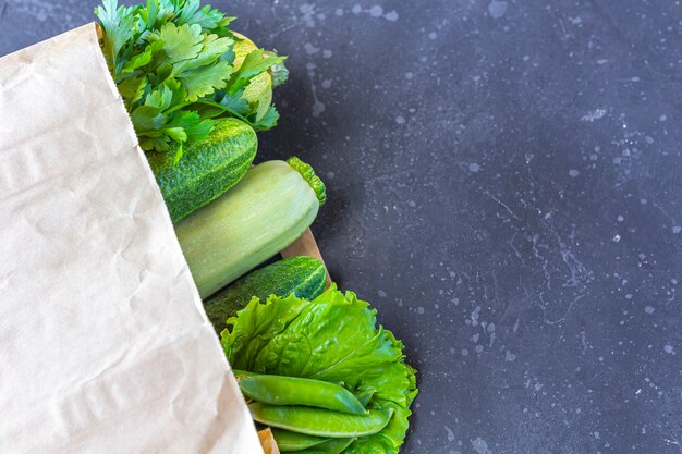 Sac en papier avec différents légumes verts sains