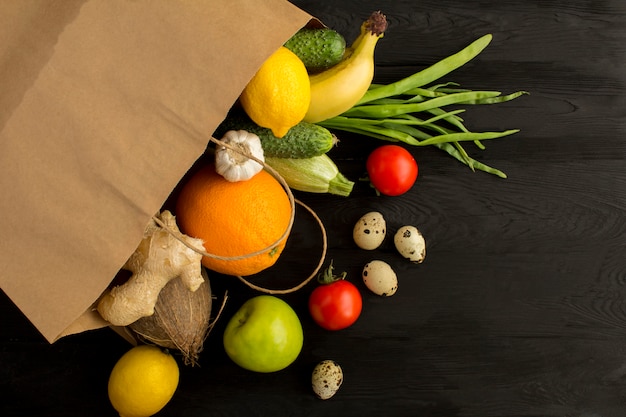 Sac En Papier Avec Des Légumes Et Des Fruits Sur La Surface En Bois Noire. Concept De Nourriture De Sac. Vue De Dessus Copiez L'espace.