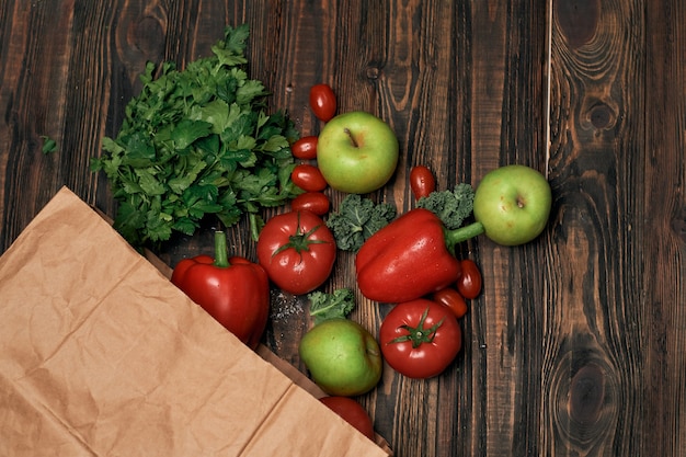 Sac en papier de légumes sur une table en bois