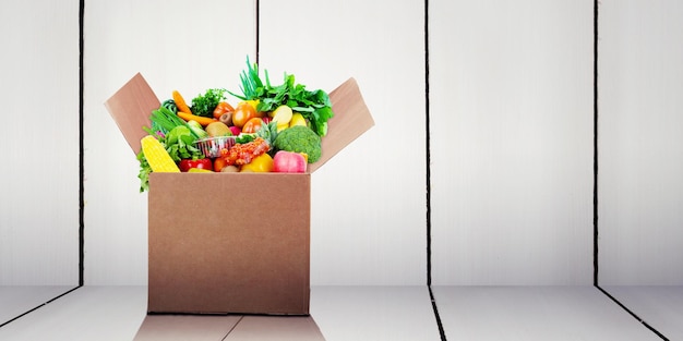 Sac en papier plein d'épicerie avec fond de planche