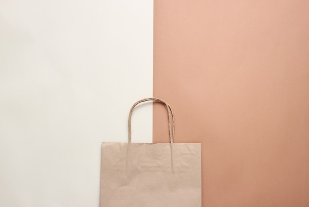 Sac en papier pour faire du shopping sur une table marron beige. Shopping d'automne, vente. Vue de dessus, minimalisme