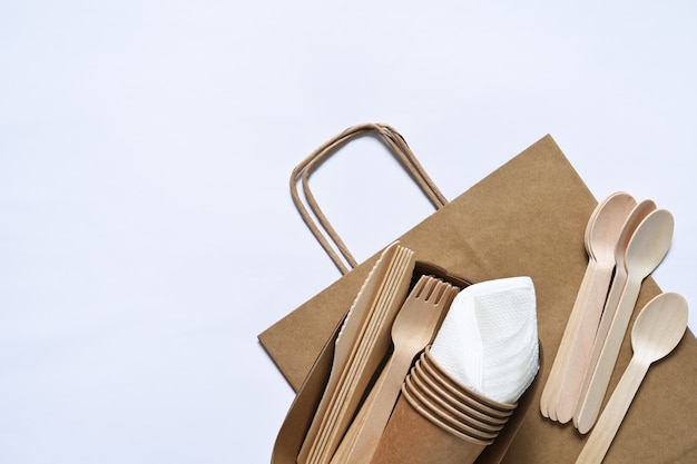 Photo sac en papier avec un set de pique-nique assiette fourchette serviettes en verre prendre soin de l'environnement