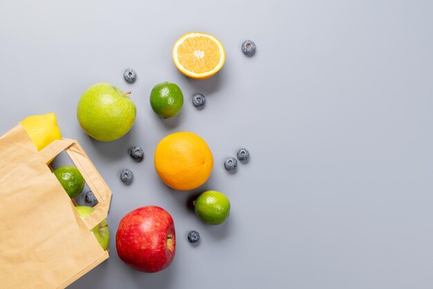 Sac en papier shopping plein d'aliments sains sur gris