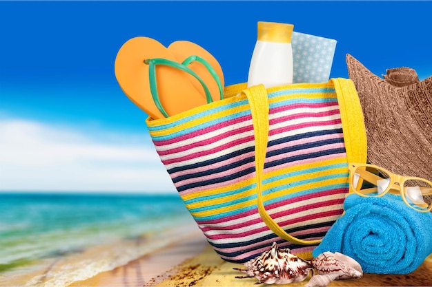 Sac de plage avec accessoires de plage sur fond de plage