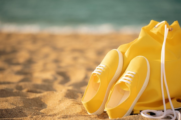 Sac de plage et baskets contre ciel et mer