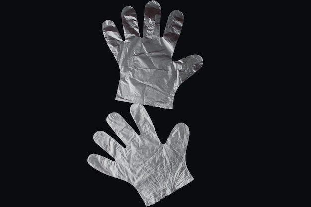 Sac en plastique avec poignées gants sur fond noir Sac en plastique utilisé pour le recyclage Concept écologie planète pollution avec plastique cellophane polyéthylène