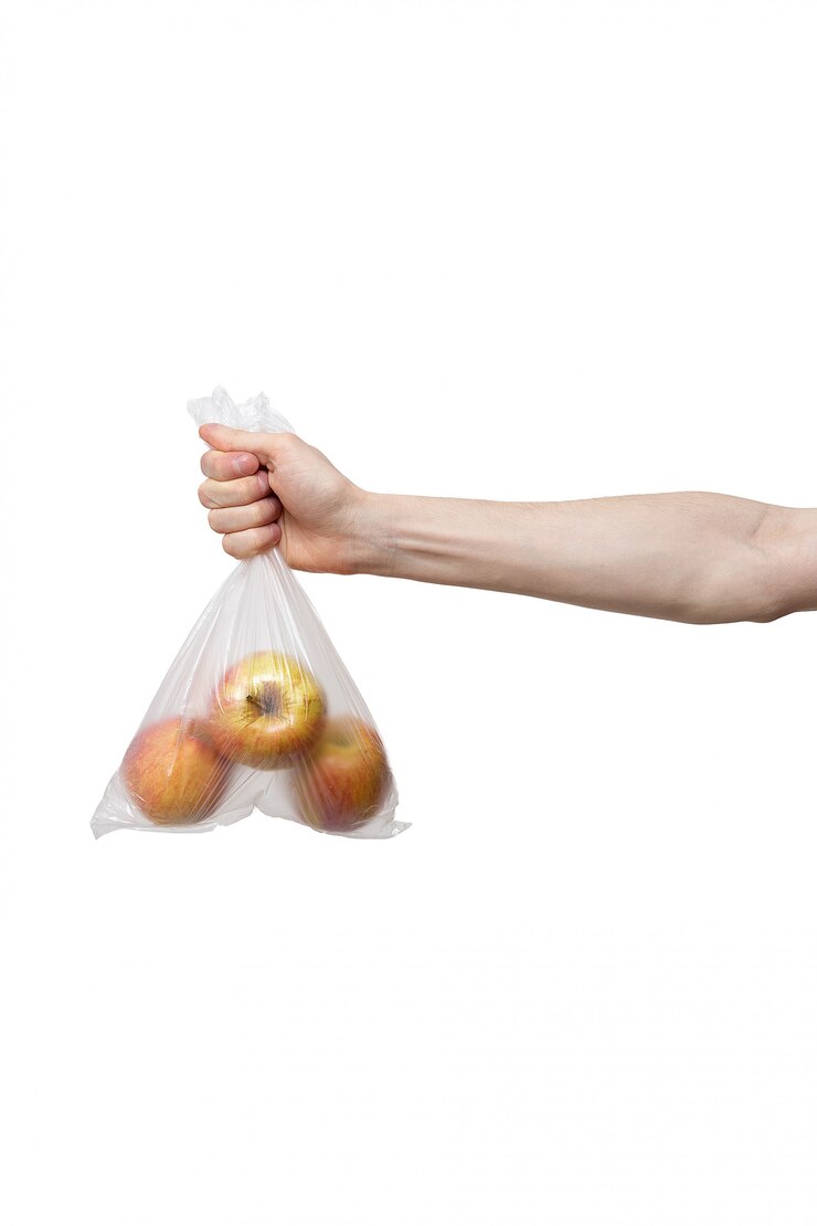 Sac en polyéthylène tenu à la main isolé sur blanc. homme tenant un paquet de pommes fraîches