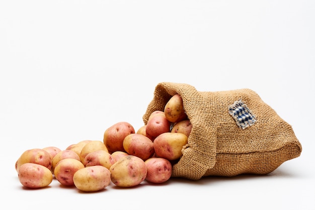 Sac avec pommes de terre sur blanc