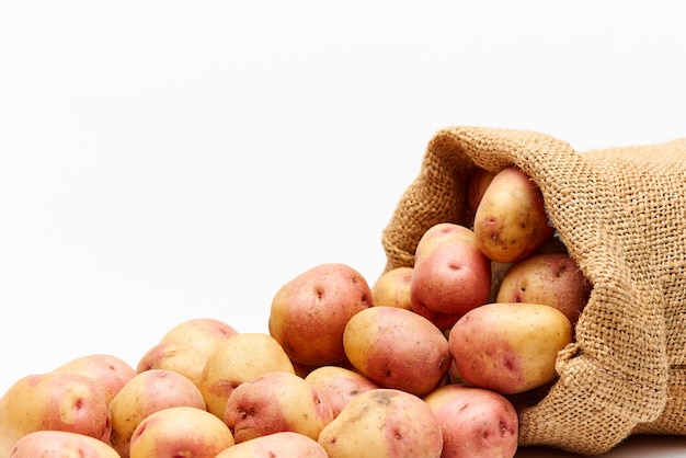 Sac avec pommes de terre sur blanc