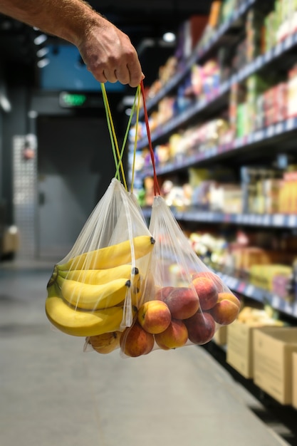 Sac de produits recyclés sans plastique, sans déchets, pour transporter des fruits.Fruit à la main dans une purée d'épicerie réutilisable en magasin